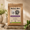 Bag of Barney & Max duck and sweet potato dog food on a wooden surface with plants in the background