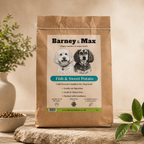Bag of Barney & Max fish and sweet potato dog food on a wooden surface with a natural background.